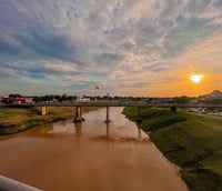 Vista aérea de Rio Branco AC ao pôr do sol, com o rio Acre e a ponte