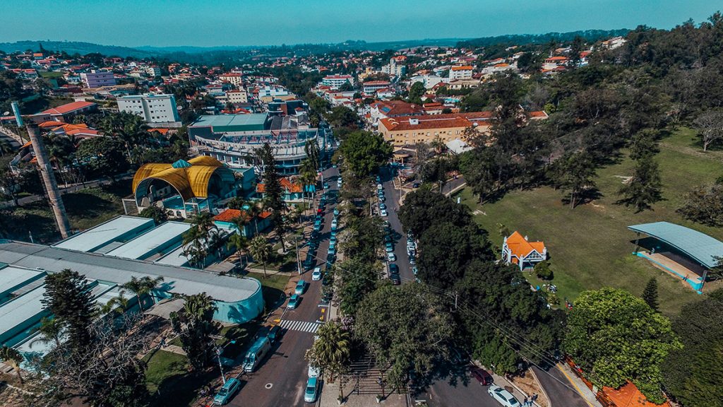 Vista aérea de Águas de São Pedro SP, com áreas verdes e construções baixas, em dia ensolarado