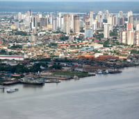 Vista panorâmica de Belém do Pará ao pôr do sol, com o Rio Guajará e o skyline da cidade.