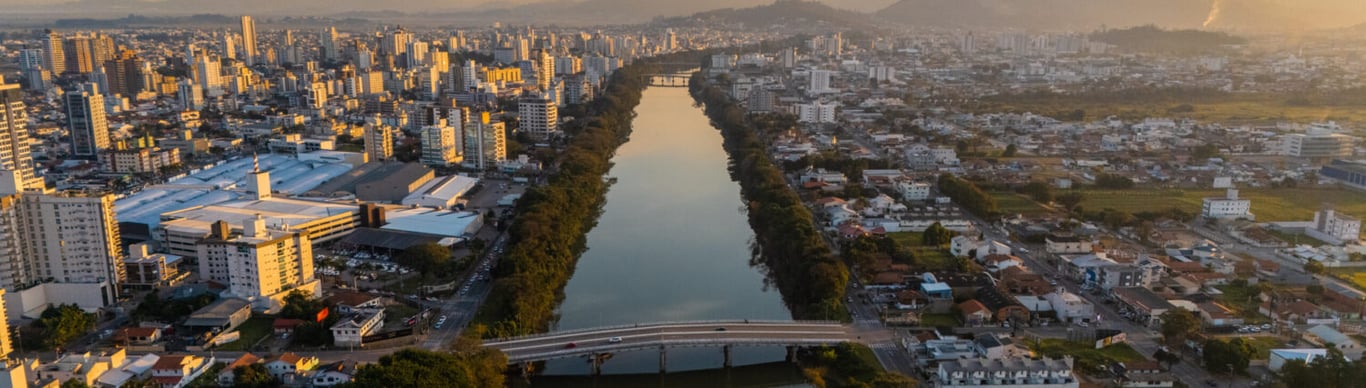 Centro de Tubarão (SC) com o rio e ponte ao fundo, vista aérea em dia claro