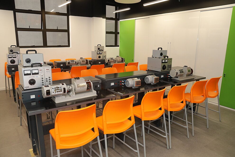 Ambiente acadêmico em laboratório de engenharia elétrica, com bancadas e equipamentos