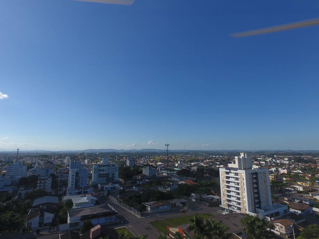 Vista aérea de Içara, com prédios e vegetação sob céu claro