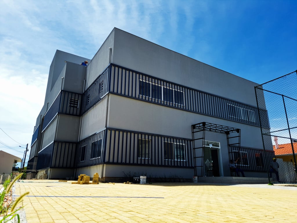 Fachada da sede da Prefeitura de Governador Celso Ramos SC, com bandeiras e arquitetura moderna sob céu azul