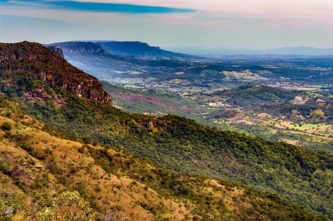 Paisagem do sudoeste de Goiás ao pôr do sol, com campos agrícolas e estrada ao longe