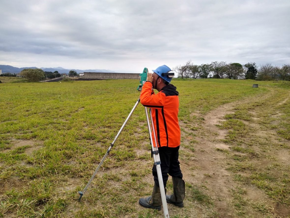 Profissional de topografia utilizando estação total em área urbana