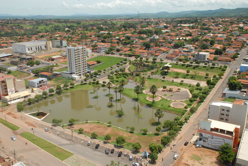 Vista aérea de São Luís de Montes Belos, com lago, áreas verdes e edificações urbanas