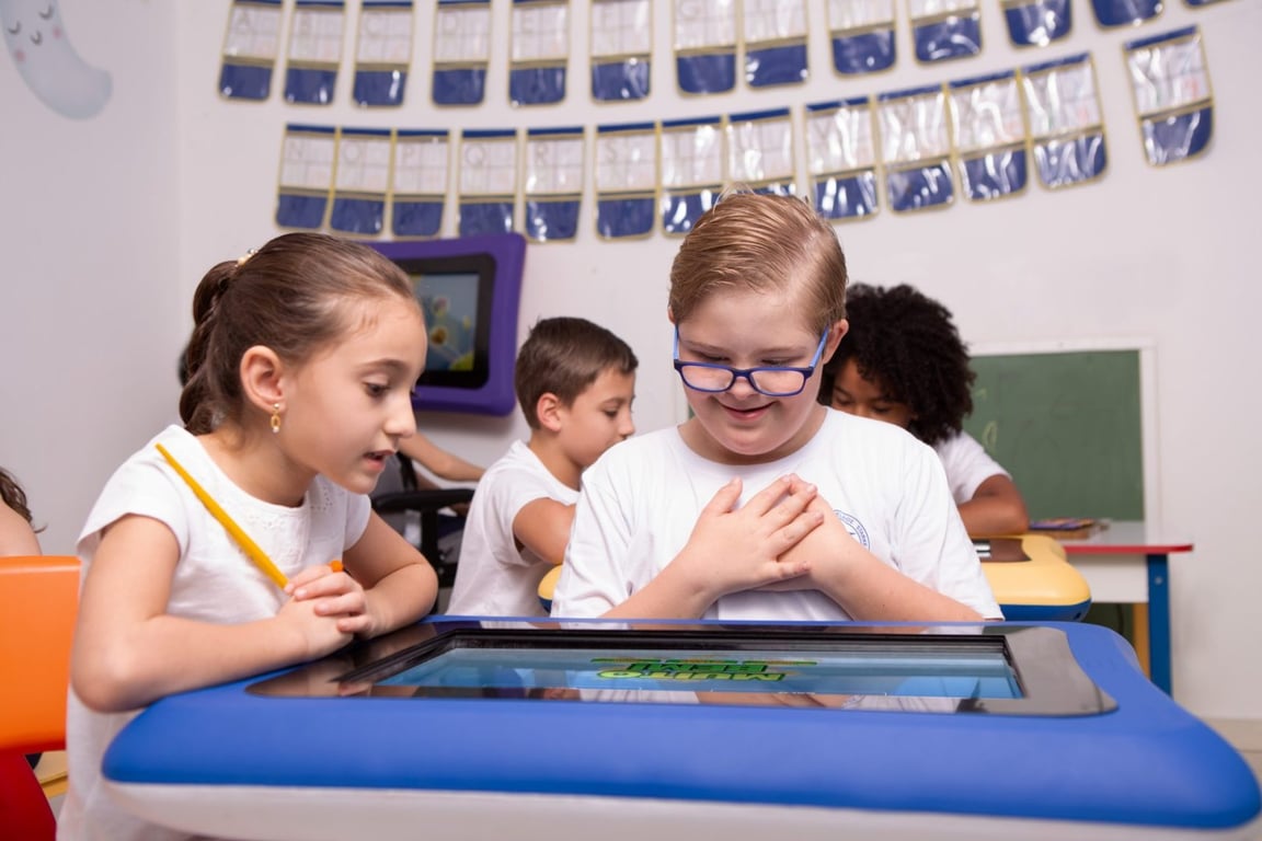 Ambiente escolar com crianças e docente em atividade, representando rotina pedagógica e uso de recursos didáticos