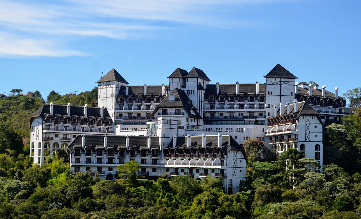 Paisagem urbana em região montanhosa, típica do Vale do Paraíba, com arquitetura moderna integrada à natureza.