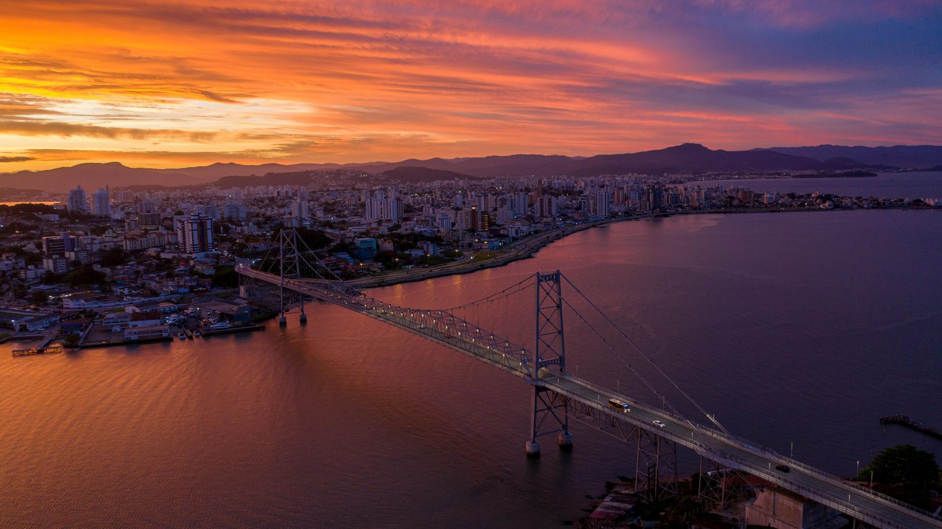 Vista aérea de Florianópolis com a Ponte Hercílio Luz ao pôr do sol