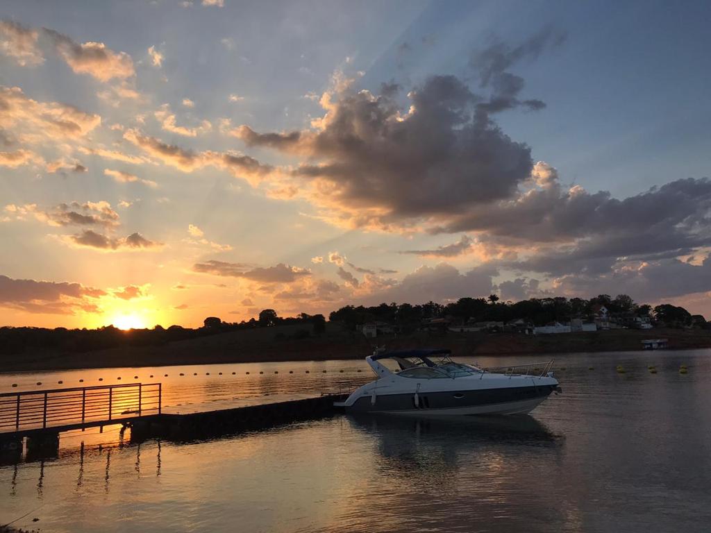 Vista do Lago de Furnas em Fama MG ao pôr do sol, com píer e embarcação ao fundo