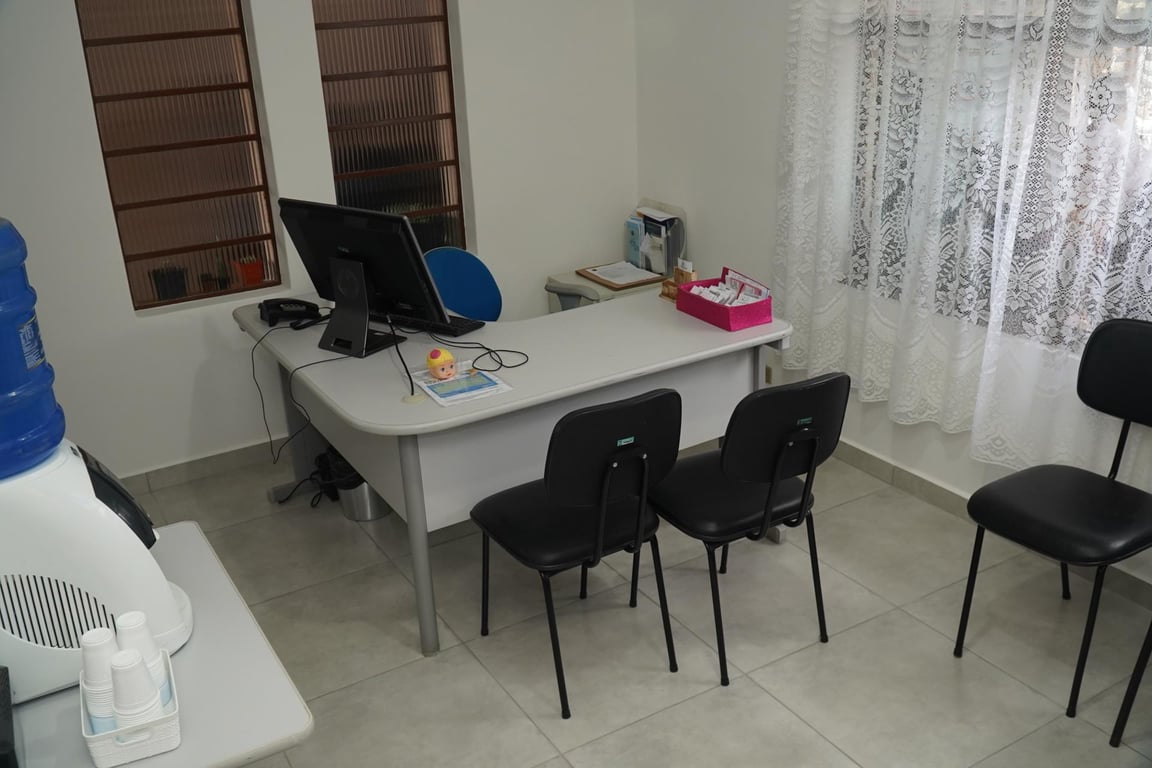 Ambiente de atendimento em unidade de assistência social, com mesas e cadeiras