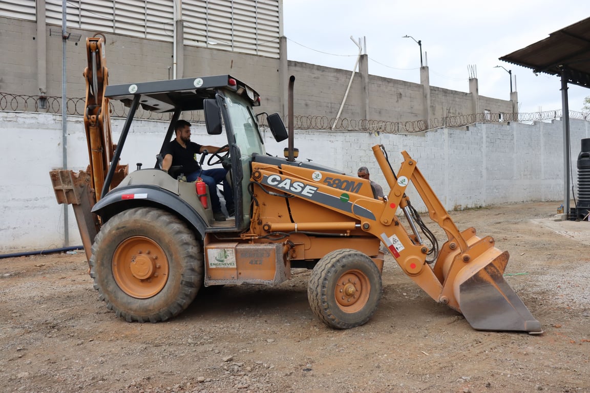 Retroescavadeira em manutenção de via rural