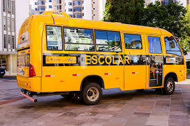 Ônibus escolar amarelo em via urbana, imagem horizontal