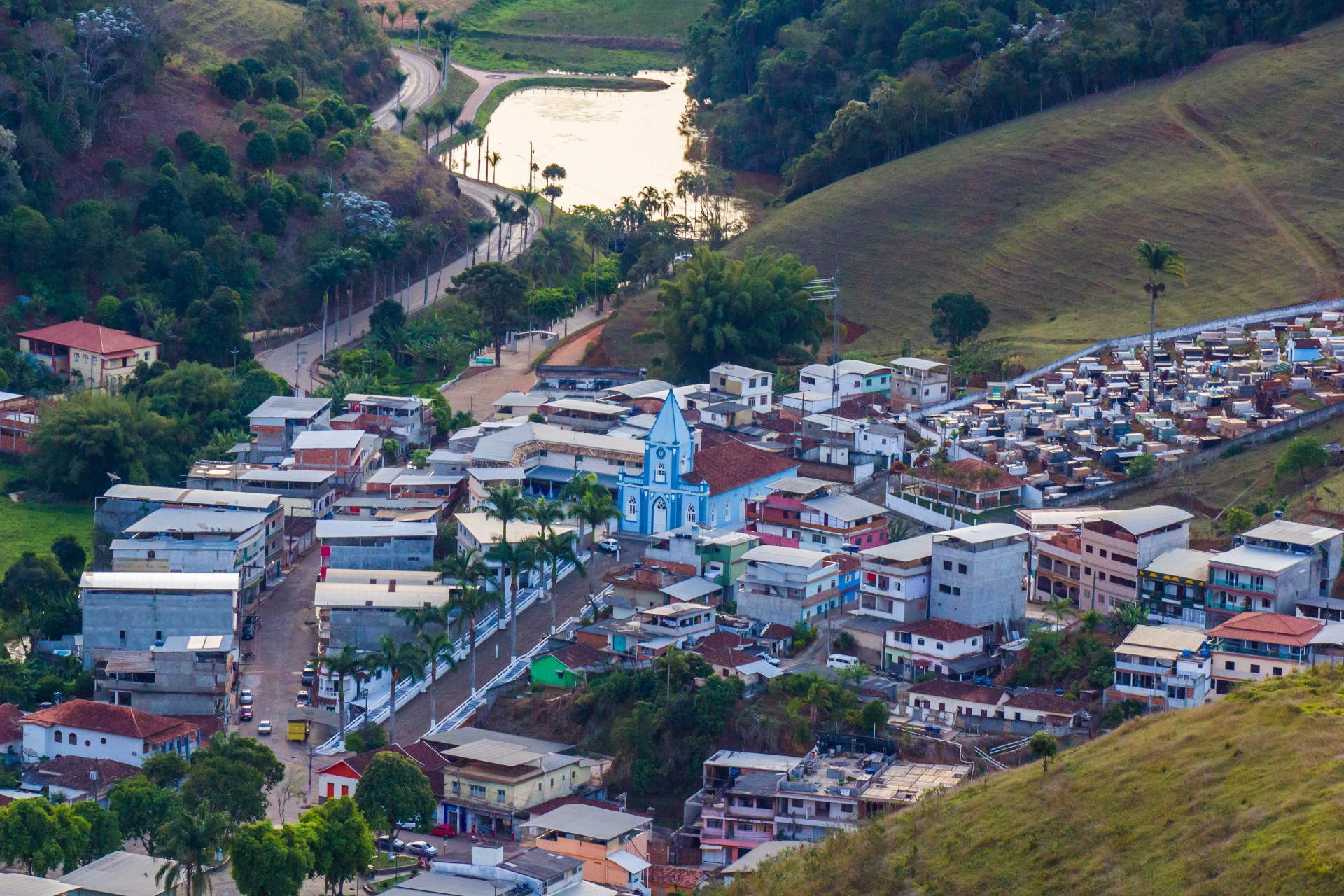 Vista aérea de cidade pequena com praça e igreja, típica do interior de Minas