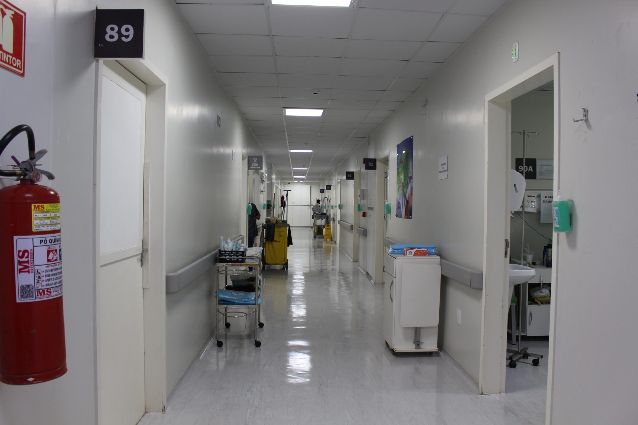 Corredor de hospital universitário moderno com equipe médica ao fundo