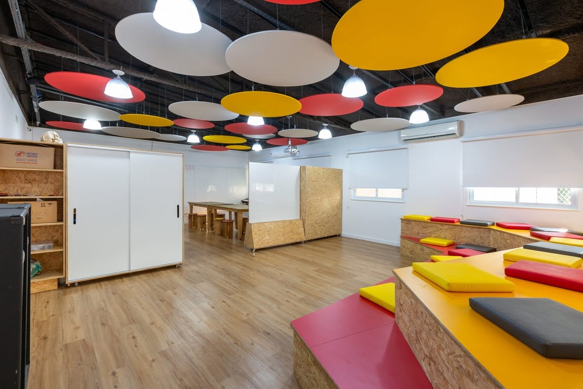 Sala de aula da rede municipal, com mesas e cadeiras organizadas e quadro ao fundo