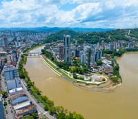 Vista aérea de Blumenau SC com o rio Itajaí-Açu e prédios de arquitetura germânica.