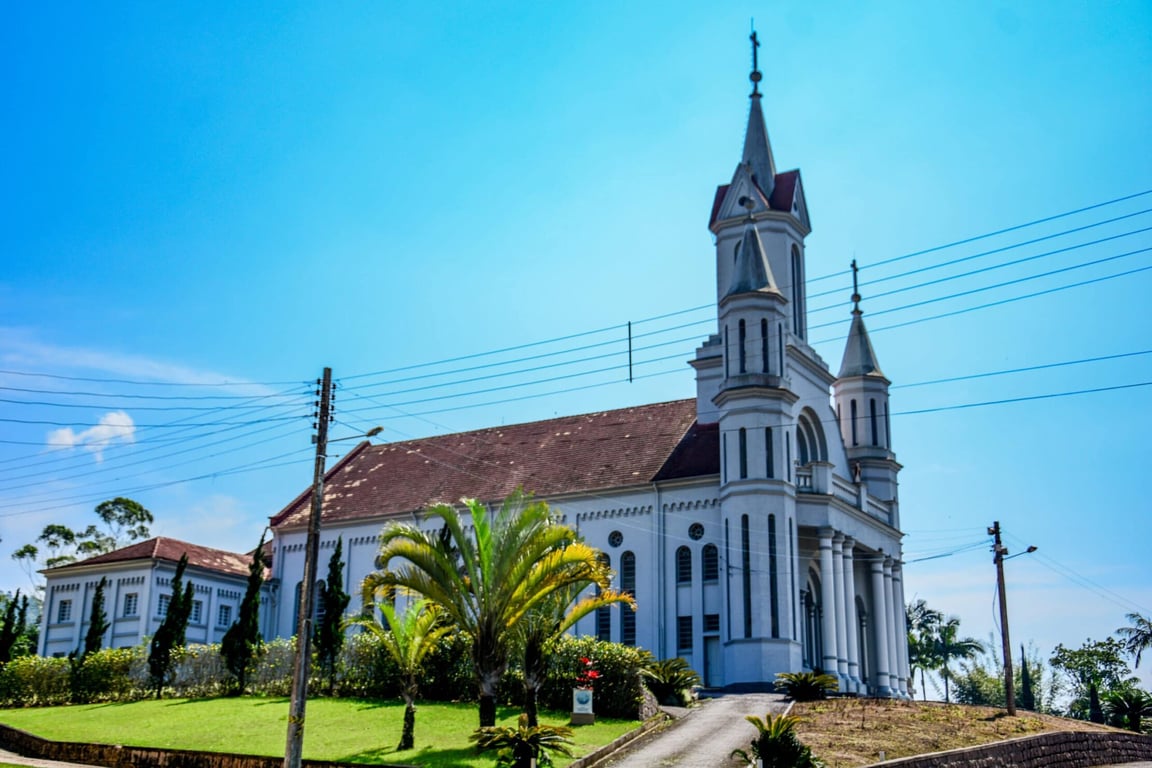 Paisagem urbana de Rodeio SC com igreja e vegetação ao redor