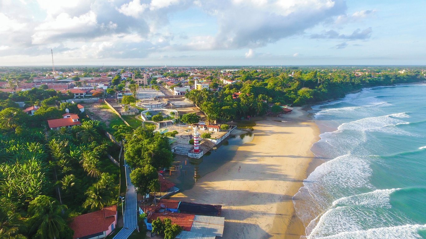 Paisagem costeira de Paracuru, com praia, dunas e mar em dia ensolarado