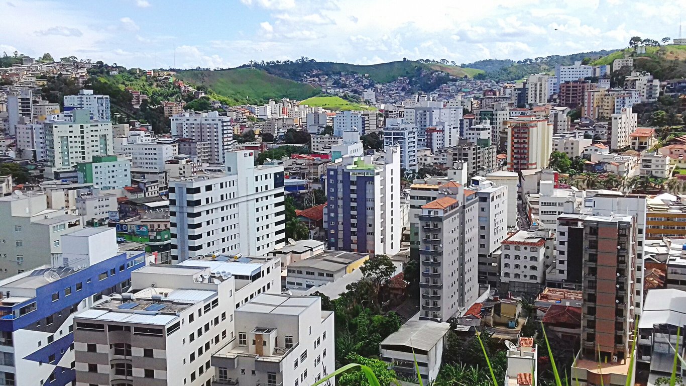 Vista aérea da cidade de Viçosa, Minas Gerais, área urbana cercada por morros verdes