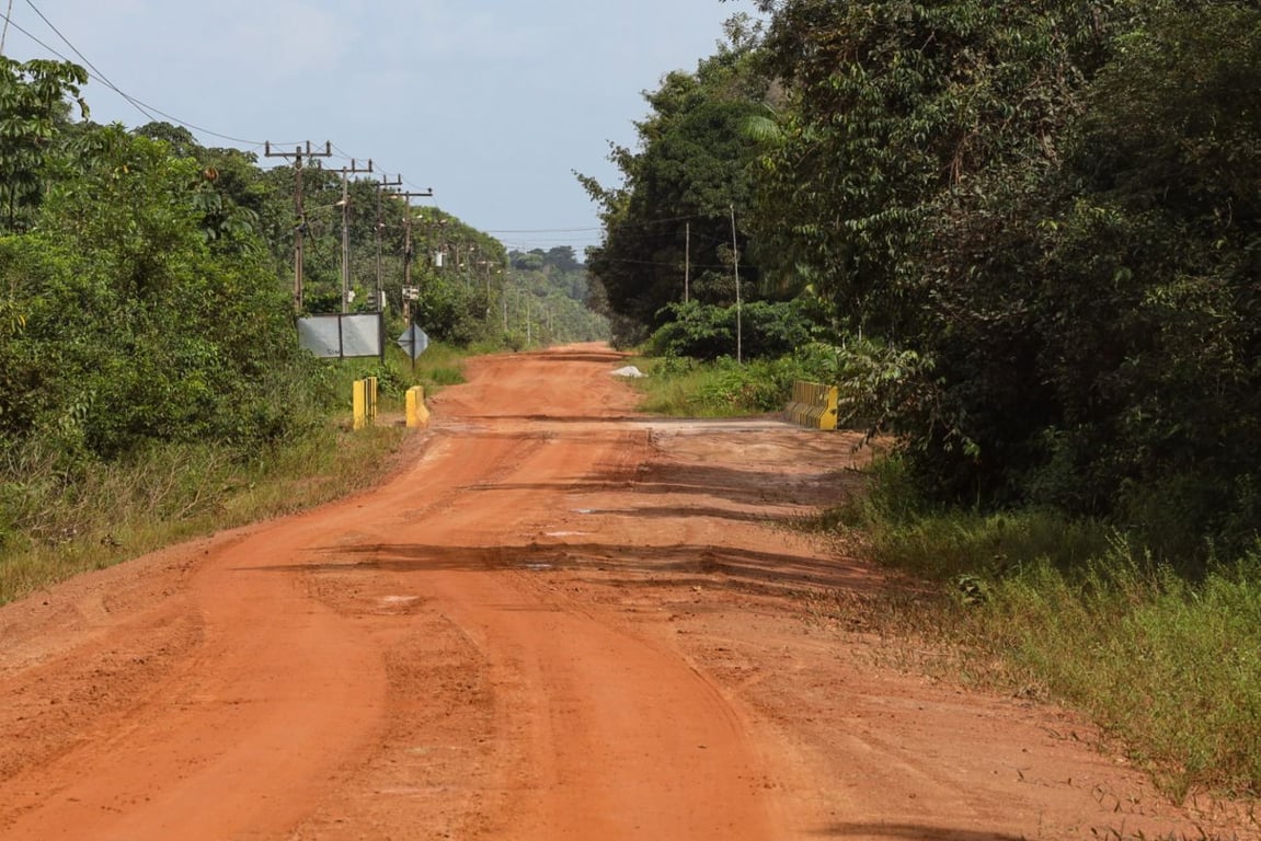 Estrada vicinal na Amazônia com ponte de madeira sobre igarapé, simbolizando a zona rural do Pará