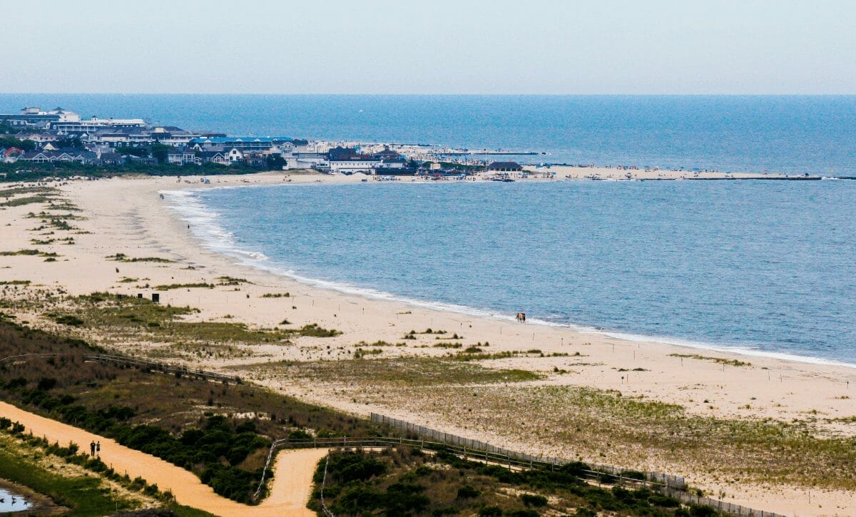 Vista aérea da orla de Maceió AL, com mar azul e prédios ao fundo