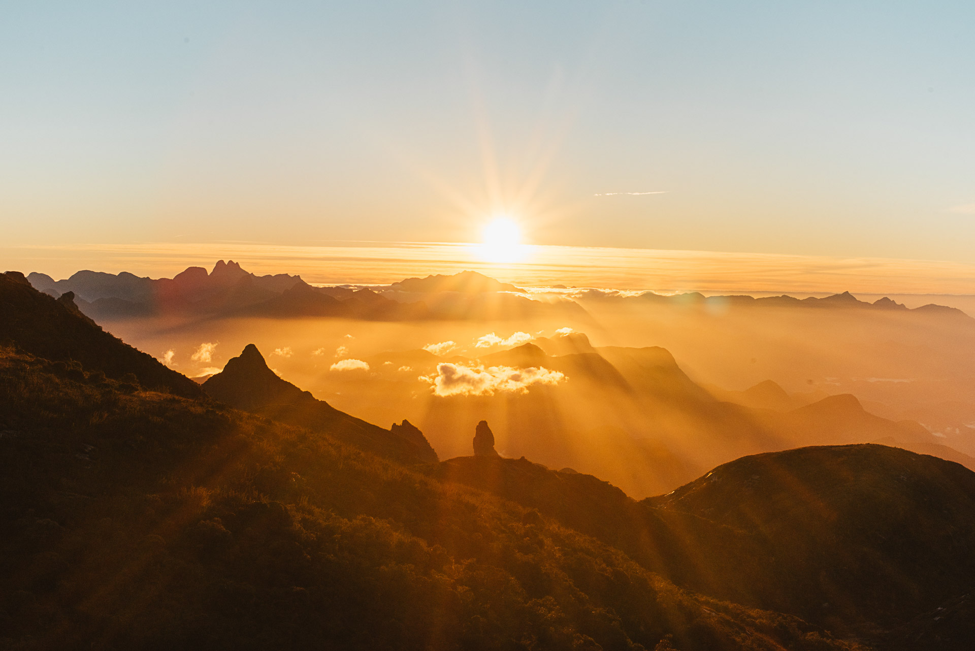 Vista panorâmica do Parque Nacional da Serra dos Órgãos com o pico Dedo de Deus ao pôr do sol