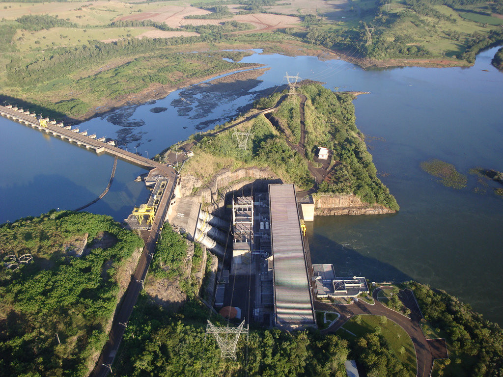 Vista aérea da Usina Salto Caxias no Rio Iguaçu, com áreas rurais ao redor, representando o Sudoeste do Paraná
