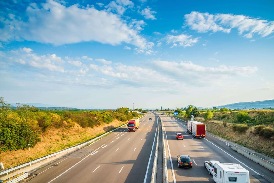 Rodovia brasileira ao entardecer com caminhões em movimento