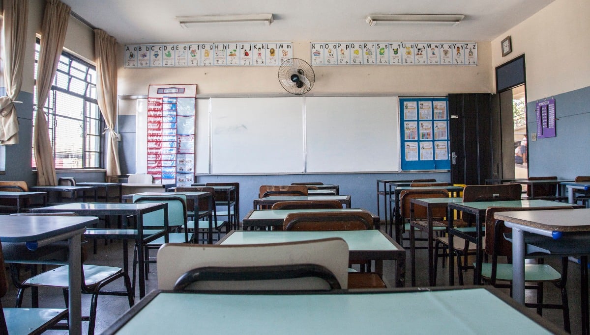 Sala de aula iluminada com carteiras organizadas