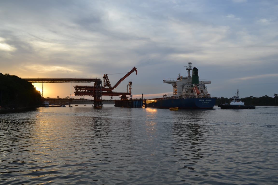 Vista aérea do Porto do Rio de Janeiro ao entardecer, com navios mercantes e a cidade ao fundo