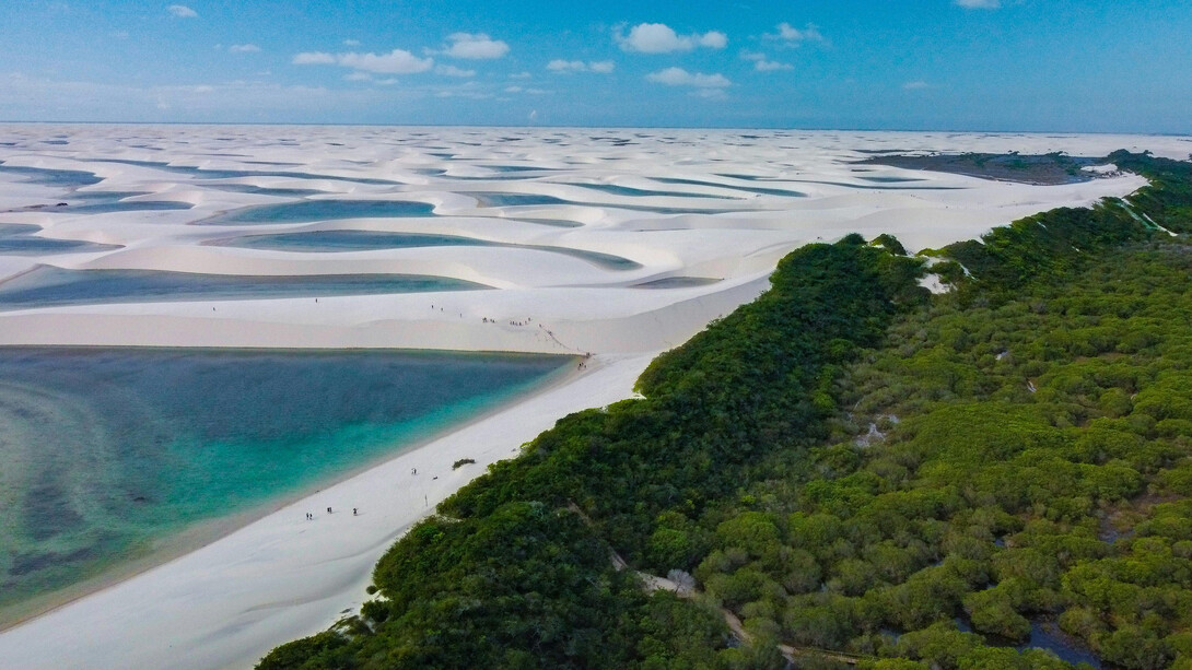 Dunas e lagoas dos Lençóis Maranhenses ao fundo, sob céu claro
