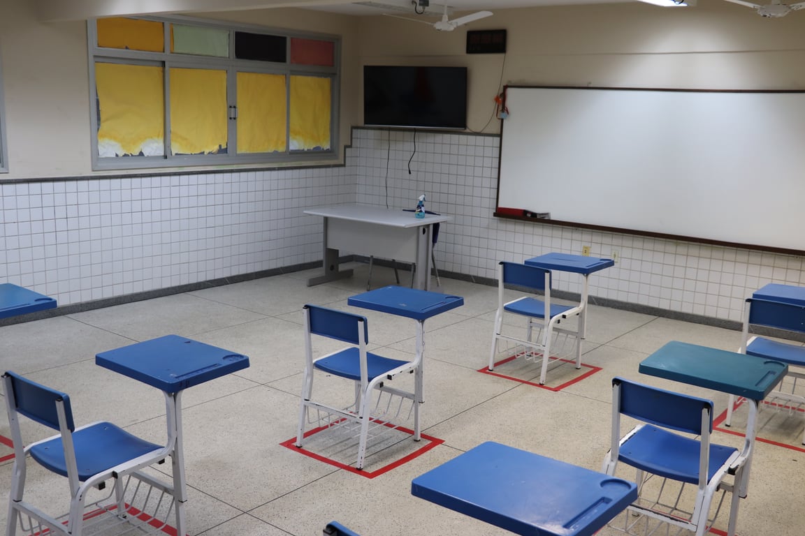 Sala de aula da rede pública, ambiente organizado com carteiras e material escolar