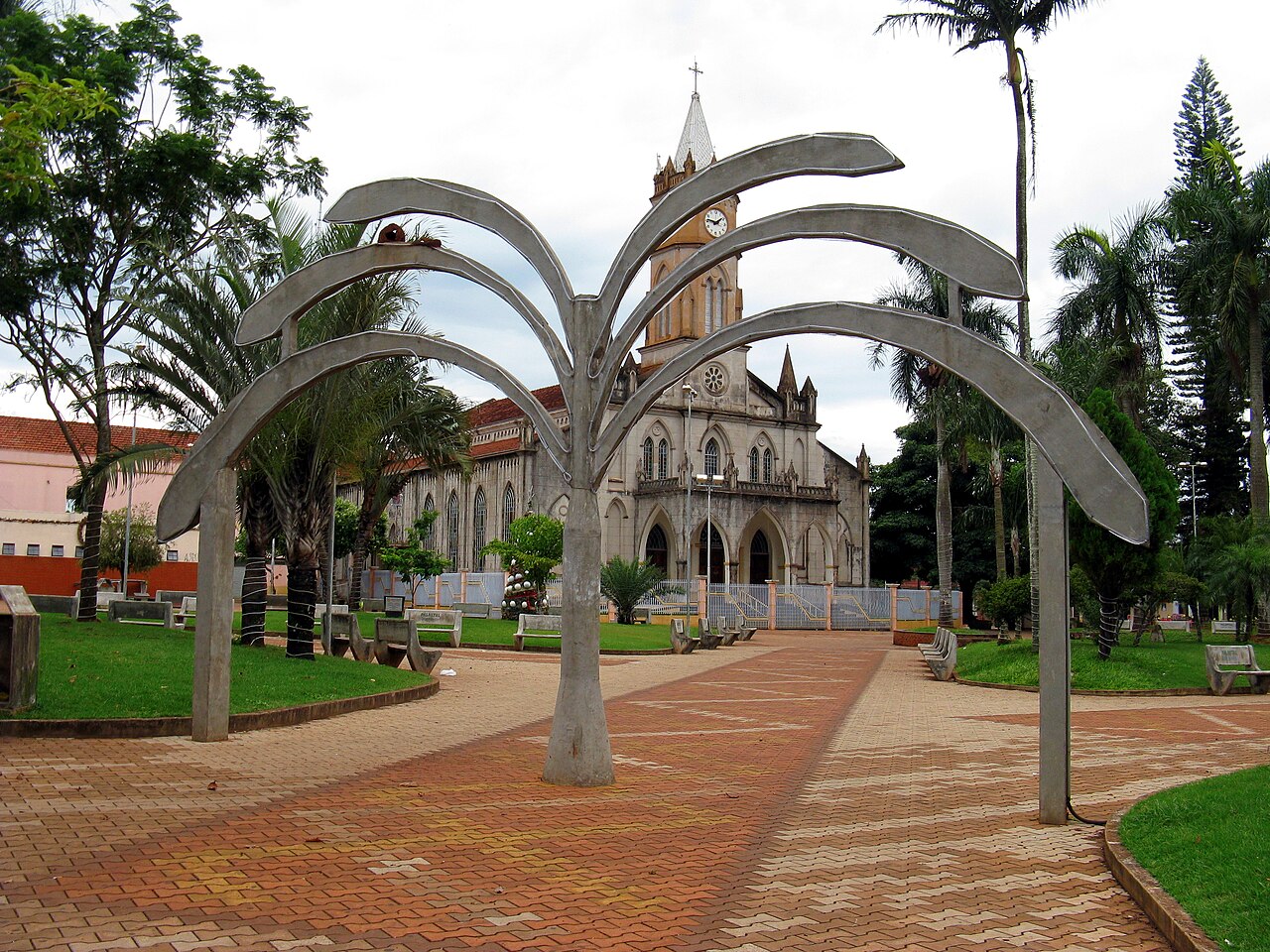 Praça central de Palmital SP, com igreja ao fundo e área arborizada