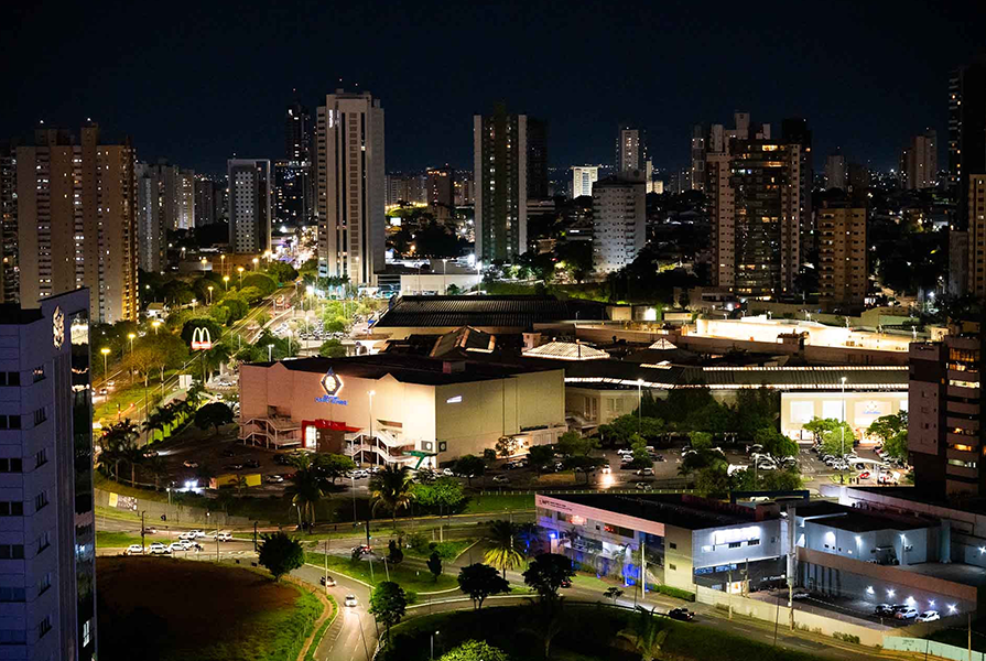 Vista urbana de Confresa à noite, com ruas iluminadas e comércio.