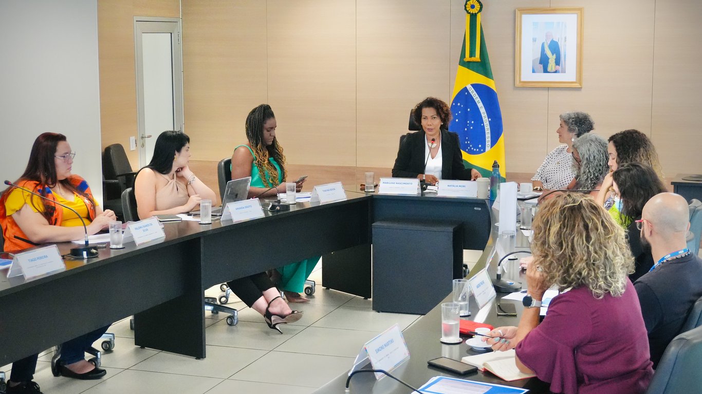 Equipe feminina em reunião em órgão público, referência à pauta de políticas para mulheres