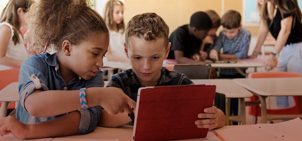 Estudantes em ambiente de prova, com cadernos e canetas