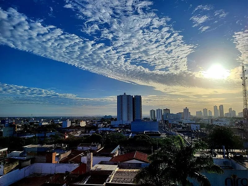 Vista aérea de Feira de Santana BA ao entardecer, com avenidas iluminadas e skyline urbano.