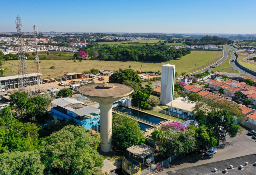 Estação de tratamento de água com reservatórios e área urbana ao fundo