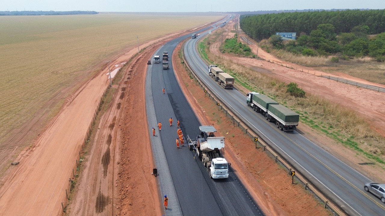 BR-163 no norte de Mato Grosso, com caminhões e vegetação ao fundo
