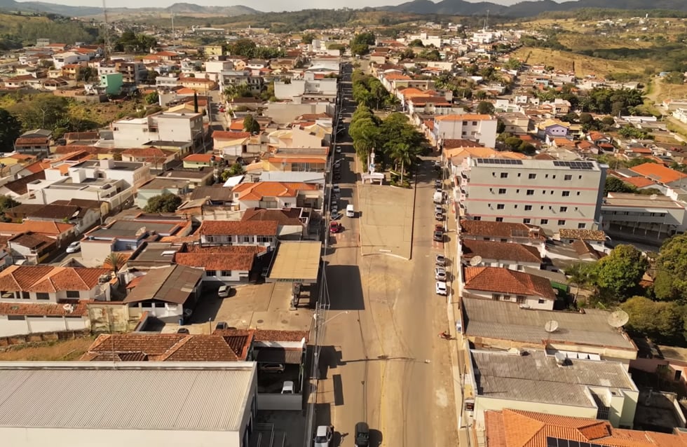 Vista aérea de Bom Sucesso MG, com bairro residencial e vias pavimentadas, ilustrando o cenário urbano do Sul de Minas