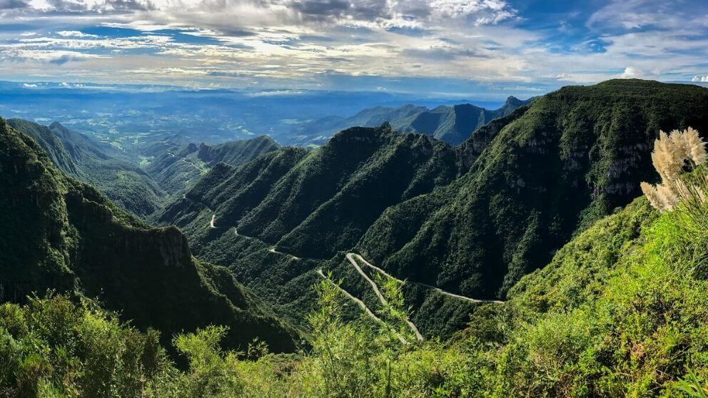 Paisagem do Vale do Itajaí, em Santa Catarina, com morros verdes e céu azul