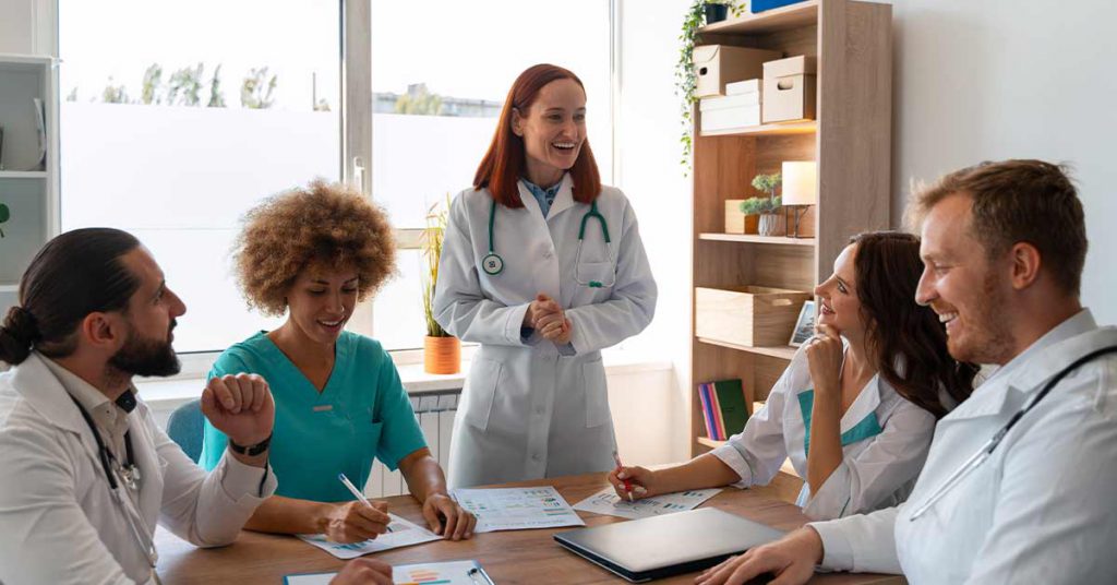 Profissionais da saúde em reunião, discutindo documentos em ambiente institucional