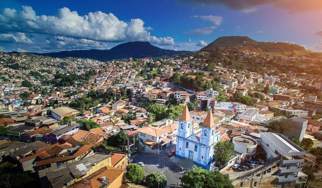 Vista panorâmica de Rosário da Limeira (MG), com igreja ao centro, casario e montanhas ao fundo