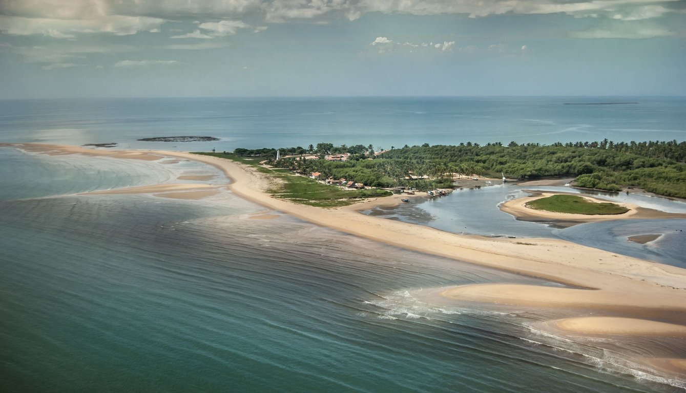 Vista aérea do litoral de Prado e Corumbau, no sul da Bahia, com mar azul e vila de pescadores.