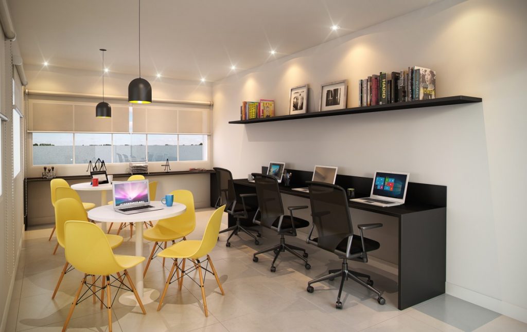 Ambiente de escritório moderno com mesas, notebooks e iluminação natural