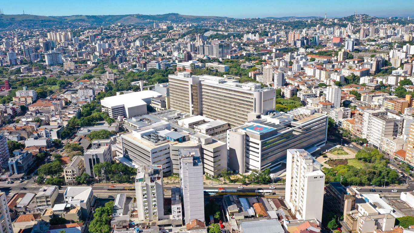 Foto aérea do Hospital de Clínicas de Porto Alegre, com o skyline da cidade ao fundo
