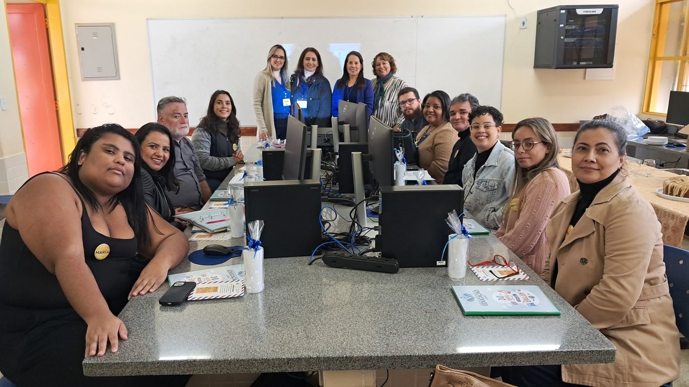Sala de aula pública organizada com profissionais em atividade de capacitação