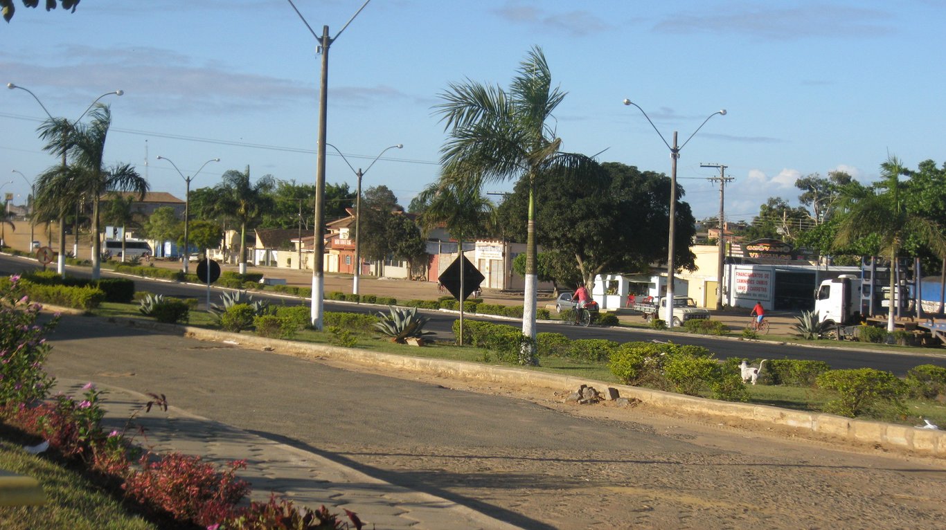 Vista urbana de Pedro Canário ES, com avenida arborizada e prédios de baixo gabarito