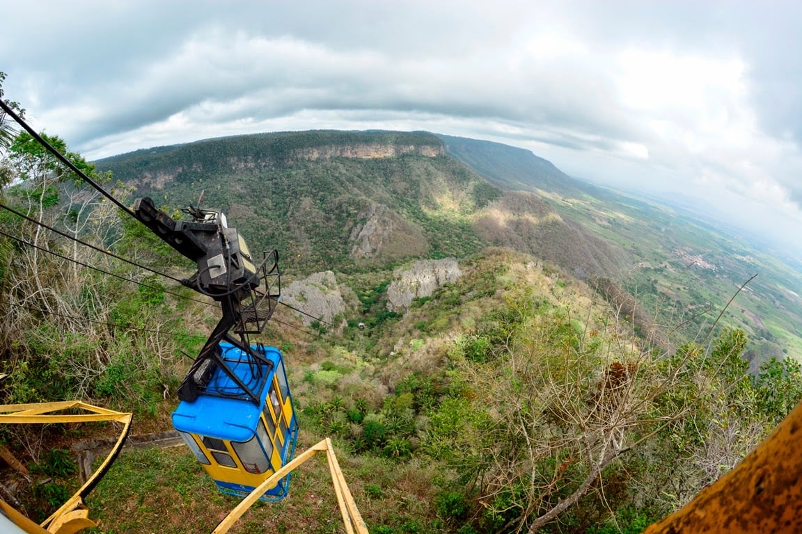 Vista urbana de Coreaú, no interior do Ceará, com casas coloridas, igreja e serra ao fundo, iluminada pela luz do fim da tarde.